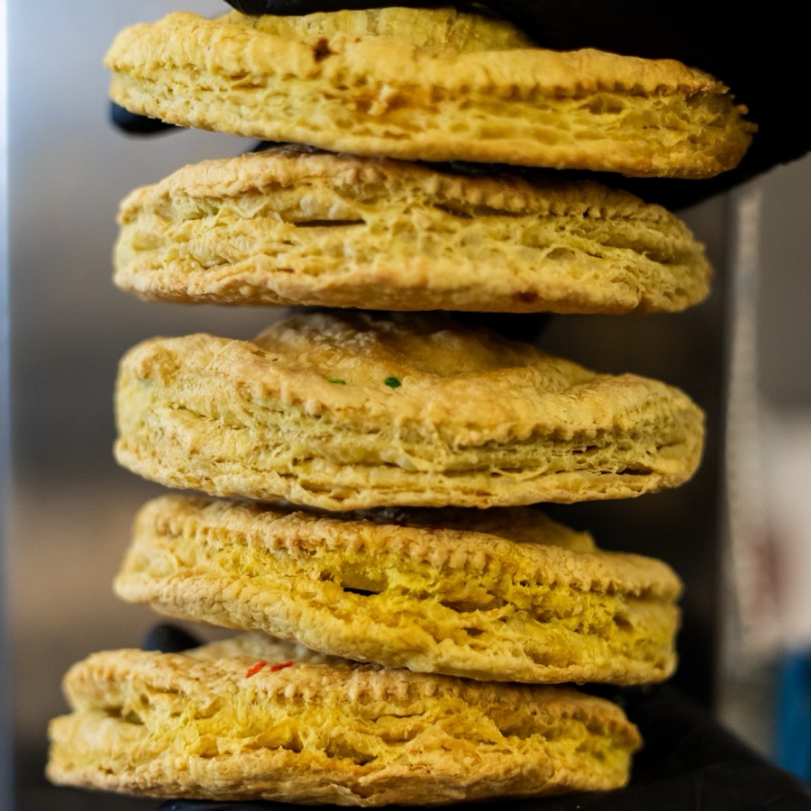 A stack of five golden Pattie Mon patties showing their flaky layered crust