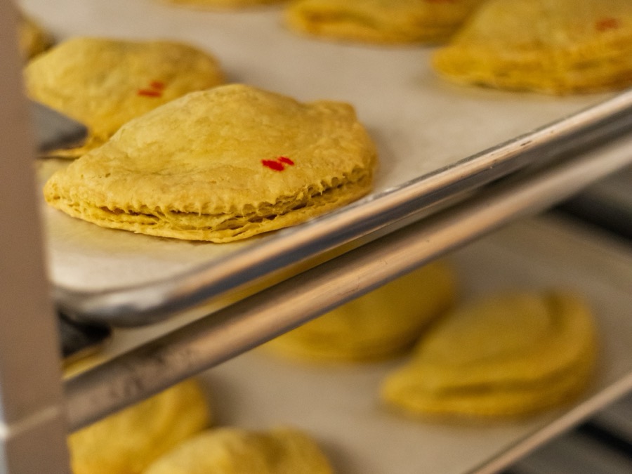 Trays of freshly baked golden patties cooling on a rack